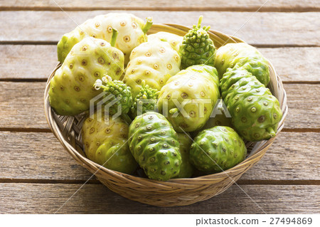 Noni fruit in the basket on wooden table 27494869
