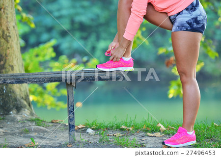 Runner girl tying laces shoes at the bench 27496453