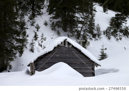 Old wooden hut covered with snow in winter forest at gray day 27496550