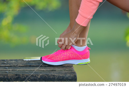 Runner girl tying laces shoes at the bench Runner girl tying laces shoes at the bench 27497019