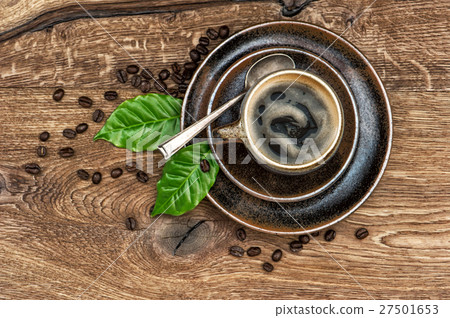 Black coffee beans and leaves on wooden table Black coffee beans and leaves on wooden table 27501653