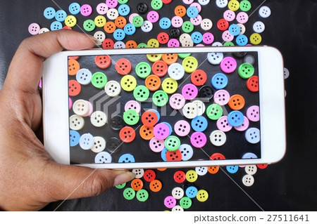Taking a photo of sewing buttons with smart phone 27511641
