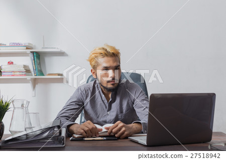 Handsome bearded man sitting at desk. serious expression 27518942