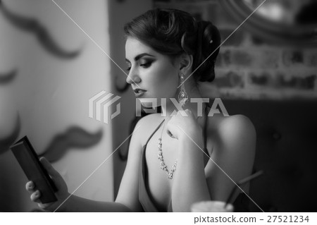 Retro image. The girl looks in the mirror 27521234