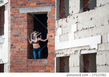 Woman in window of unfinished building 27522982