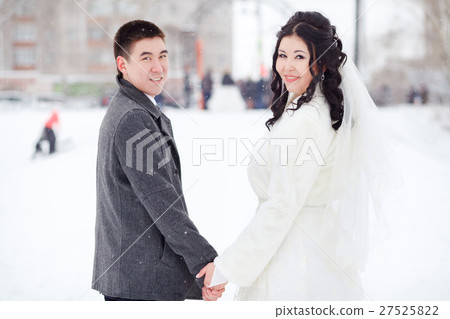 Winter wedding, bride and groom holding hands 27525822