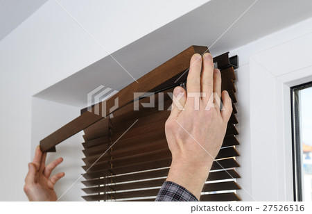 Installing wooden blinds. 27526516