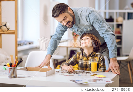 Positive delighted male standing behind son 27540908
