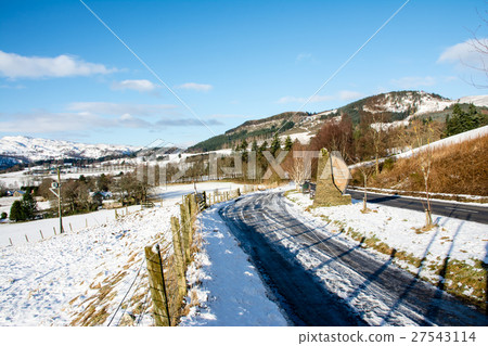 Snow scene in the outskirts of Scotland Road leading to a snowy mountain that can be seen far away Snow scene in the outskirts of Scotland Road leading to a snowy mountain that can be seen far away 27543114