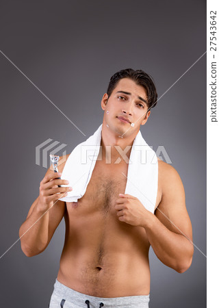 Handsome man shaving against dark background Handsome man shaving against dark background 27543642