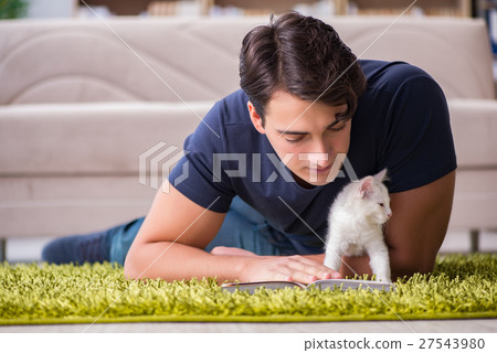 Young handsome man playing with white kitten Young handsome man playing with white kitten 27543980