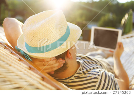 Man in a hammock with tablet computer  27545263