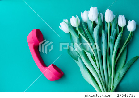 Handset and white tulips bouquet 27545733
