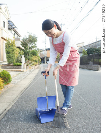 A woman cleaning the front of the house A woman cleaning the front of the house 27549259