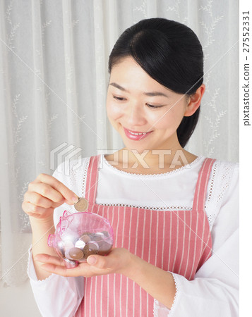 有存錢罐和硬幣的一名婦女 有存錢罐和硬幣的一名婦女 27552331