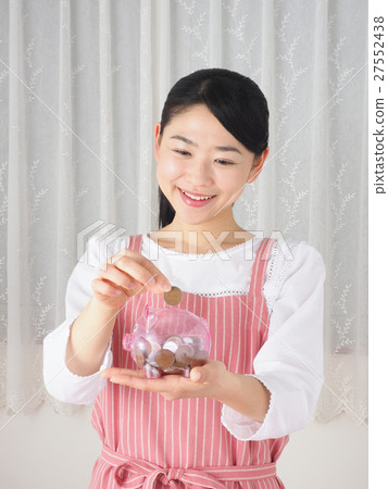 A woman with a piggy bank and coin 27552438