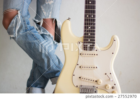 A young man with an electric guitar Leaning agains 27552970