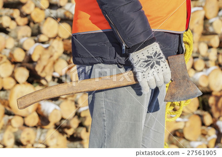 Lumberjack with ax and rope near pile of logs 27561905