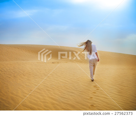 Blond woman walking in Sahara desert. Tunisia. Blond woman walking in Sahara desert. Tunisia. 27562373