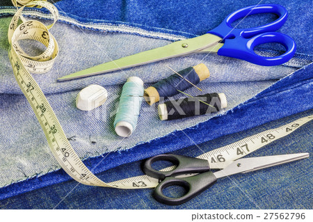 Threads with needles, scissors, tape measure on de Threads with needles, scissors, tape measure on de 27562796