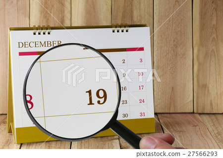 Magnifying glass in hand on calendar you can look Nineteenth date of month,Focus number nineteen in December. Magnifying glass in hand on calendar you can look Nineteenth date of month,Focus number nineteen in December. 27566293