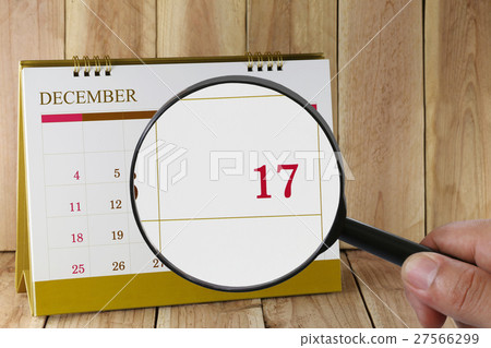 Magnifying glass in hand on calendar you can look Seventeenth date of month,Focus number seventeen in December. Magnifying glass in hand on calendar you can look Seventeenth date of month,Focus number seventeen in December. 27566299