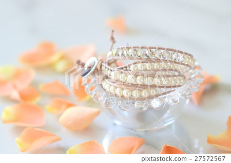 A table photo of a rose petal and a handmade bracelet A table photo of a rose petal and a handmade bracelet 27572567