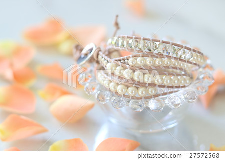 A table photo of a rose petal and a handmade bracelet 27572568
