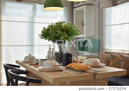 Breakfast setup on wooden table with nice vase Breakfast setup on wooden table with nice vase 27578254