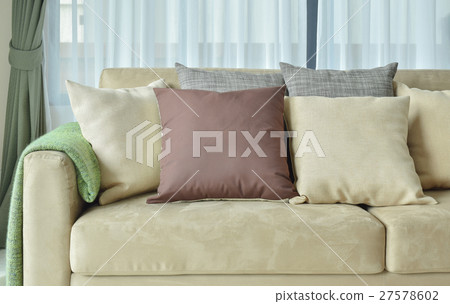 Brown pillows on light brown leather sofa 27578602