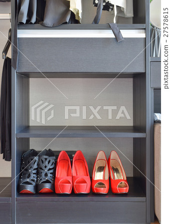 row of women's red shoes on black shelf 27578615
