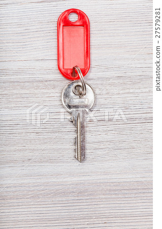 key with red blank keychain on wood table 27579281