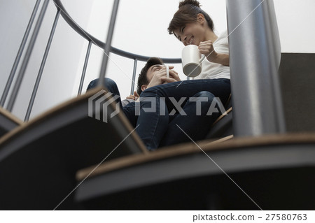 放鬆在台階的一個男人和一名婦女 放鬆在台階的一個男人和一名婦女 27580763