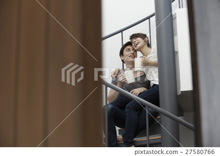 A man and a woman relaxing on the stairs A man and a woman relaxing on the stairs 27580766