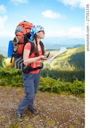 Woman hiker in mountains determines the direction 27581336