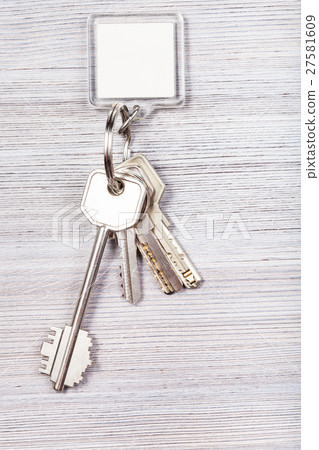 bunch of keys with key chain on wooden background 27581609