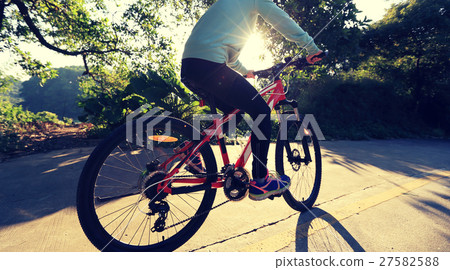 young asian woman riding bike on forest trail young asian woman riding bike on forest trail 27582588