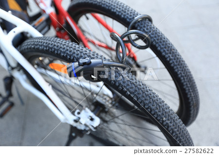 two bikes locked together in city two bikes locked together in city 27582622