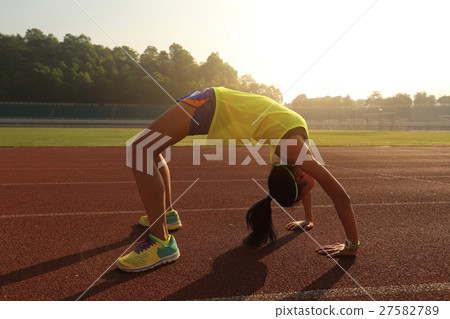 young asian woman backbending on stadium track 27582789