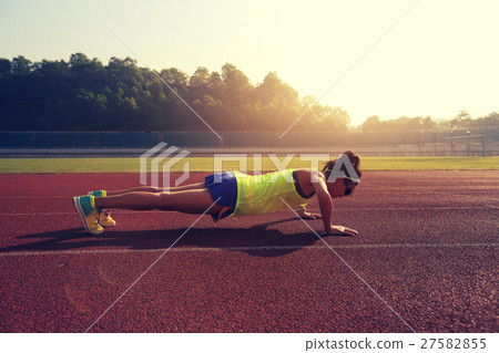 young woman runner  push up on stadium track 27582855