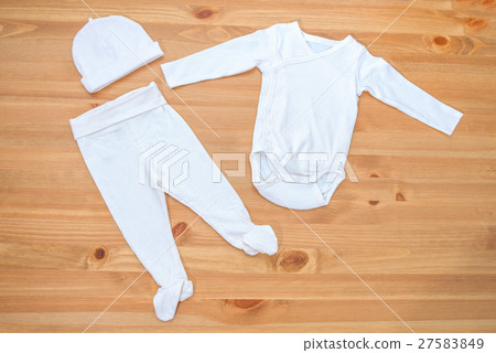 Clothes for newborn girl on a wooden background 27583849
