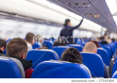 Stewardess walking the aisle of commercial 27585904