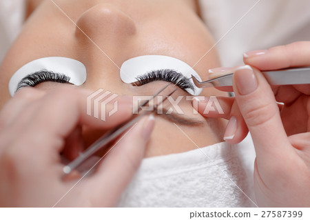 Stylist lengthening lashes for female in a beauty Stylist lengthening lashes for female in a beauty 27587399