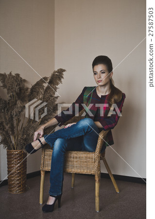 Girl in a wicker chair in the Studio 4848. 27587503