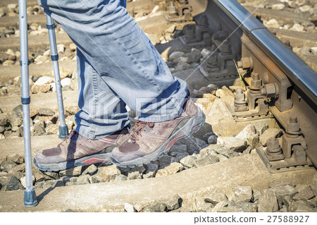Disabled man with crutches on railway  27588927