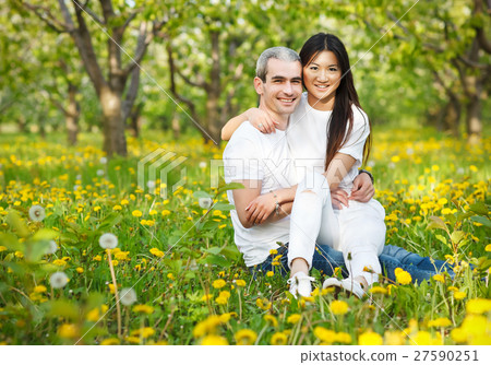 Young loving couple on green grass with dandelion Young loving couple on green grass with dandelion 27590251