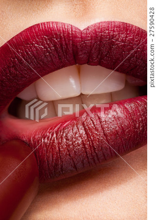 Applying lipstick on red lips 27590428