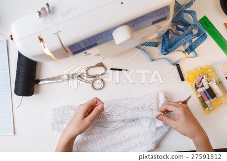 Dressmaker working with white cloth Dressmaker working with white cloth 27591812