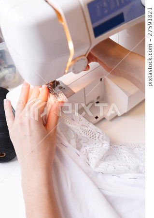 Seamstress makes stitch on sewing-machine Seamstress makes stitch on sewing-machine 27591821