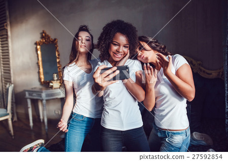 Three pretty girls grimace and make selfie on the 27592854